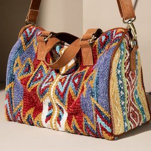 Beautiful woven Winthrop Boston Bagwith genuine suede handle and tassel detail.